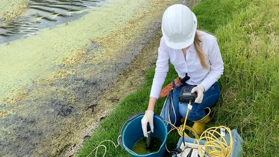 Profesional tomando muestra de agua para estudio ambiental de un cuerpo hídrico