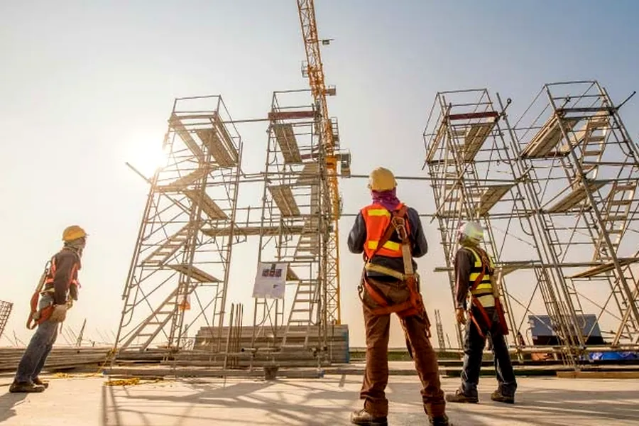 Equipo de construcción supervisando una obra en andamios